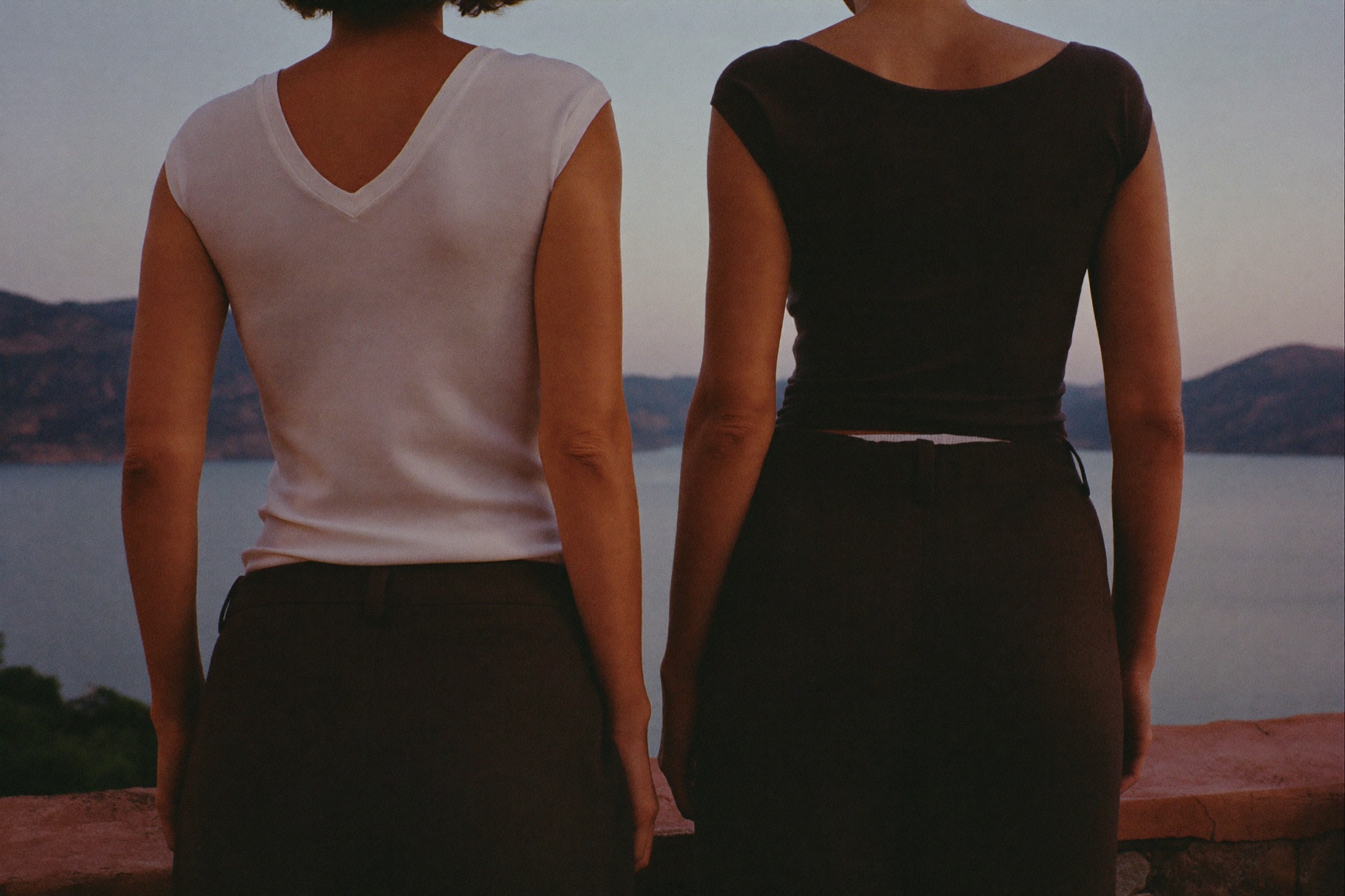 Dos mujeres de espaldas frente al lago al atardecer
