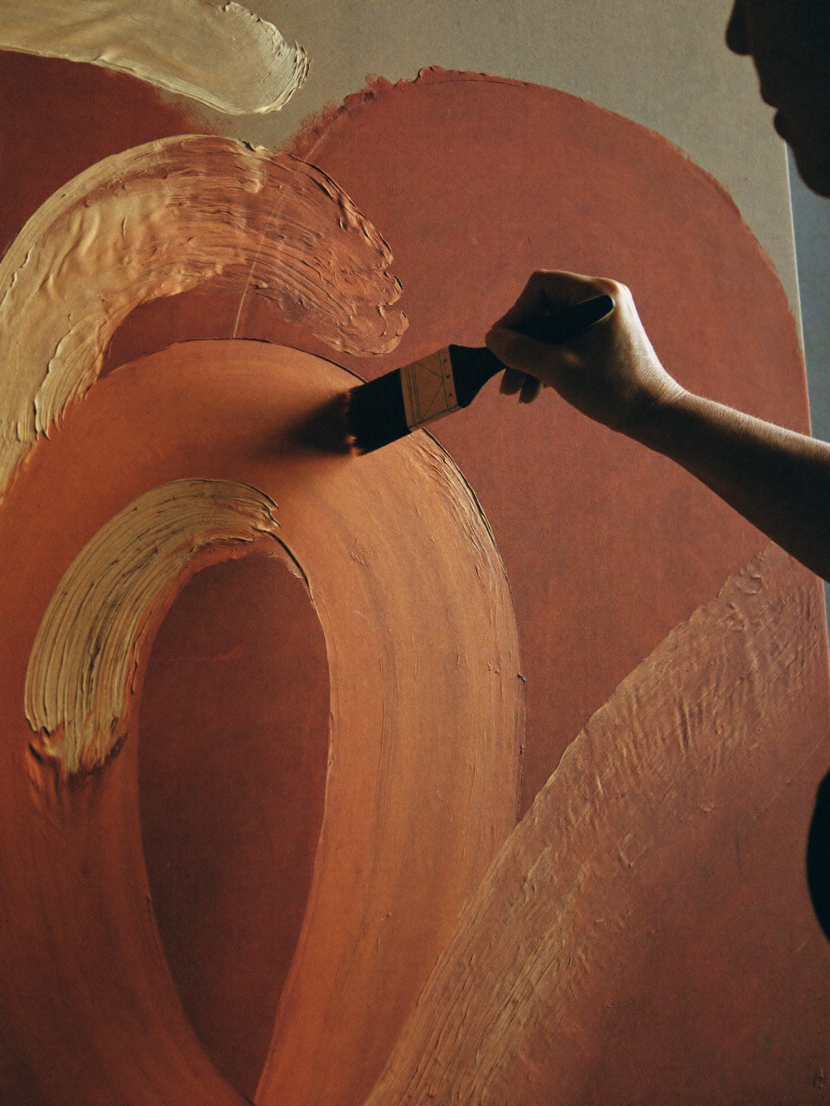 Una mano extendiendo pintura al óleo sobre un lienzo